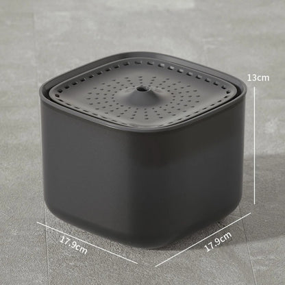 Fontaine à eau pour chat carrée gris anthracite avec dimensions : 17,9 cm de largeur par 13 cm de hauteur, plateau supérieur perforé et design minimaliste sur sol gris.