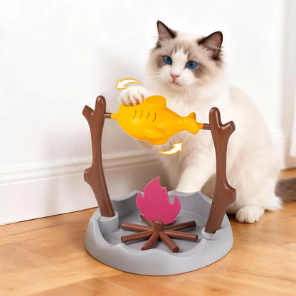 Un chat Ragdoll aux yeux bleus interagit avec la gamelle anti glouton chat interactive en forme de feu de camp. Sa patte fait tourner le réservoir jaune pour libérer des croquettes. Cette gamelle glouton ludique ralentit le repas et stimule l'intelligence de votre félin, disponible chez Les Trésors d'Owka.
