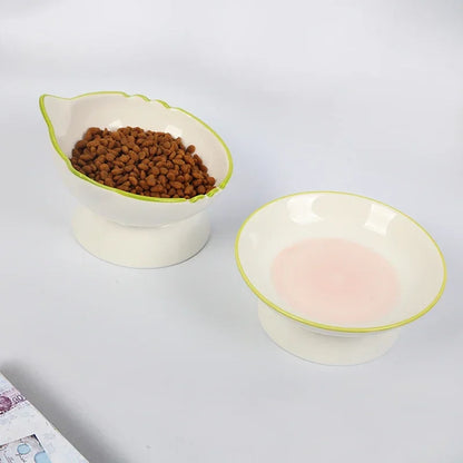 Duo de gamelle pour chat surélevée en céramique blanche avec liseré vert et motif intérieur rose poudré. Cet ensemble de gamelle chat orthopédique design assure une posture de repas naturelle et une hygiène parfaite. Une gamelle de luxe en céramique lourde et stable pour un confort digestif royal.