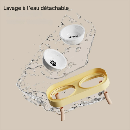Démonstration du lavage à l'eau d'une gamelle pour chat double entièrement détachable avec bols en céramique et support jaune. Cette gamelle chat ergonomique aux pieds en bois amovibles assure une hygiène parfaite et un entretien ultra-rapide pour le bien-être de votre animal. Une gamelle duo amovible idéale pour prévenir les bactéries et les irritations.