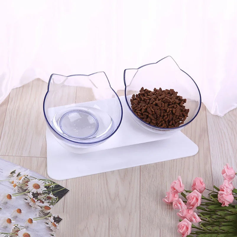 Gamelle pour chat double inclinée à 15 degrés avec deux bols transparents design oreilles de chat sur support blanc. Cette gamelle chat orthopédique assure un confort cervical optimal, protège la colonne vertébrale et facilite la digestion de votre félin. Une gamelle élégante et transparente pour surveiller l'alimentation de votre animal.