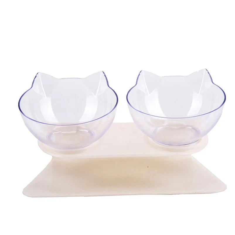 Gamelle pour chat double inclinée à 15 degrés avec deux bols transparents design oreilles de chat sur support blanc ergonomique. Cette gamelle chat orthopédique assure un confort cervical optimal, protège la colonne vertébrale et facilite la digestion de votre félin. Une gamelle élégante et moderne pour un coin repas sain et ordonné.