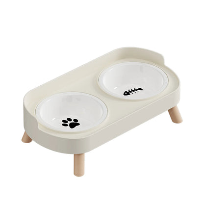 Gamelle pour chat double surélevée au design scandinave blanc cassé avec bols amovibles en céramique blanche et pieds en bois clair. Cette gamelle chat orthopédique décorée d'une patte et d'une arête de poisson assure un confort cervical optimal et une hygiène parfaite. Une gamelle duo robuste et élégante aux finitions premium pour votre animal.