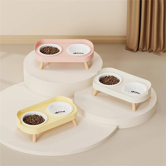 Collection de gamelle pour chat double surélevée en céramique et bois, disponible en rose, jaune et blanc pastel. Cette gamelle chat orthopédique au design scandinave avec bols amovibles assure un confort de repas optimal et une hygiène parfaite. Une gamelle duo élégante avec motif arête de poisson pour un intérieur moderne.