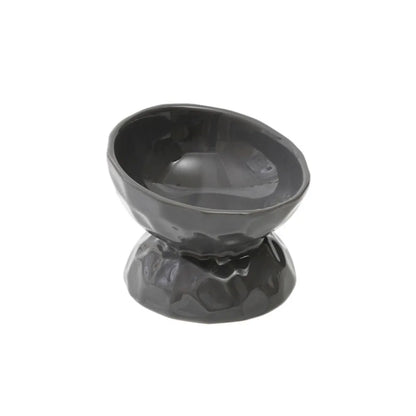 Gamelle pour chat surélevée et inclinée en céramique noire avec design martelé et fini brillant. Cette gamelle animaux ergonomique protège les cervicales et facilite la digestion grâce à son angle de 15 degrés. Une gamelle chat haut de gamme, stable et facile à nettoyer pour un confort alimentaire optimal.