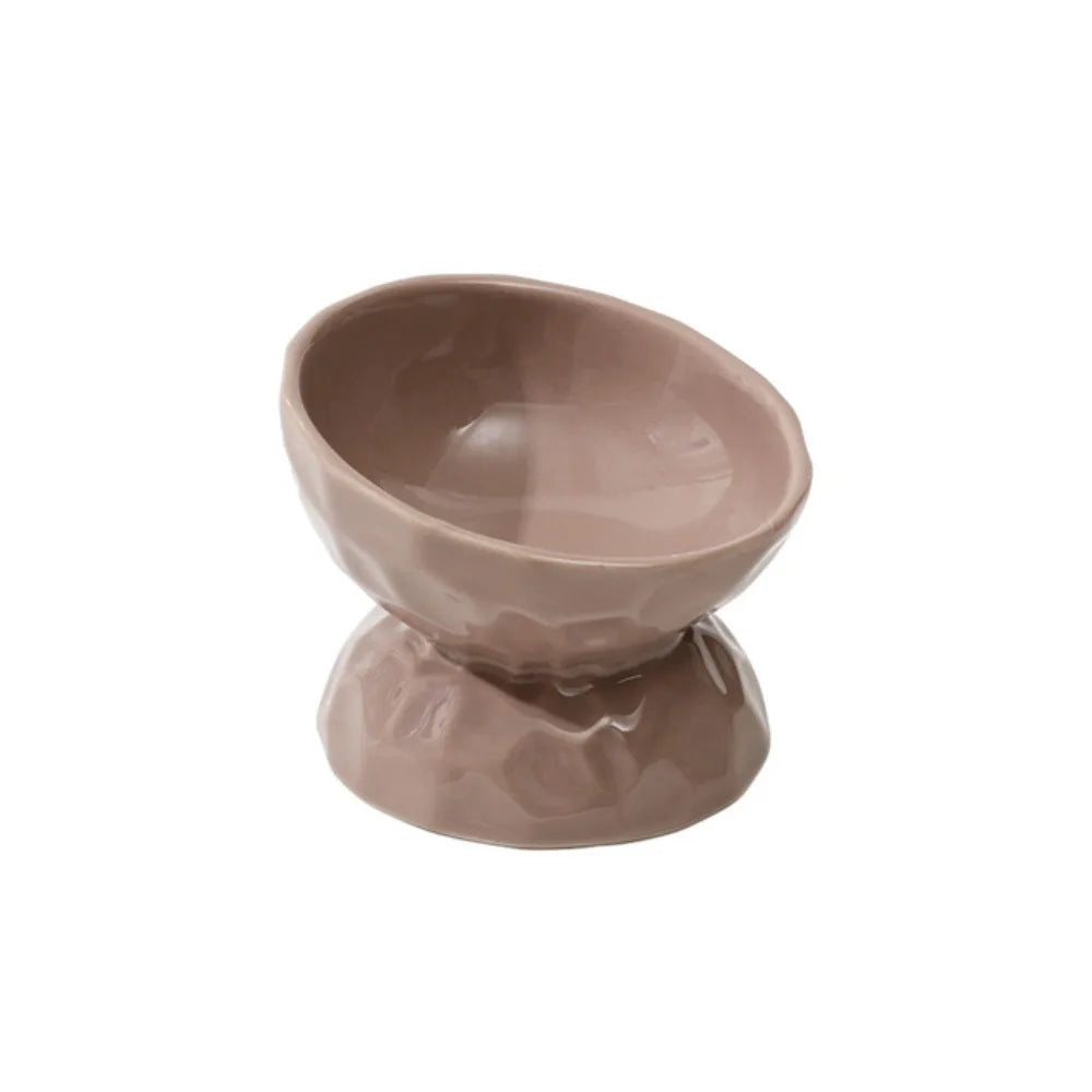 Gamelle pour chat surélevée et inclinée en céramique taupe avec texture martelée et fini brillant. Cette gamelle animaux ergonomique protège les cervicales et facilite la digestion grâce à son angle de 15 degrés. Une gamelle chat haut de gamme, stable et facile à nettoyer pour un confort alimentaire optimal.
