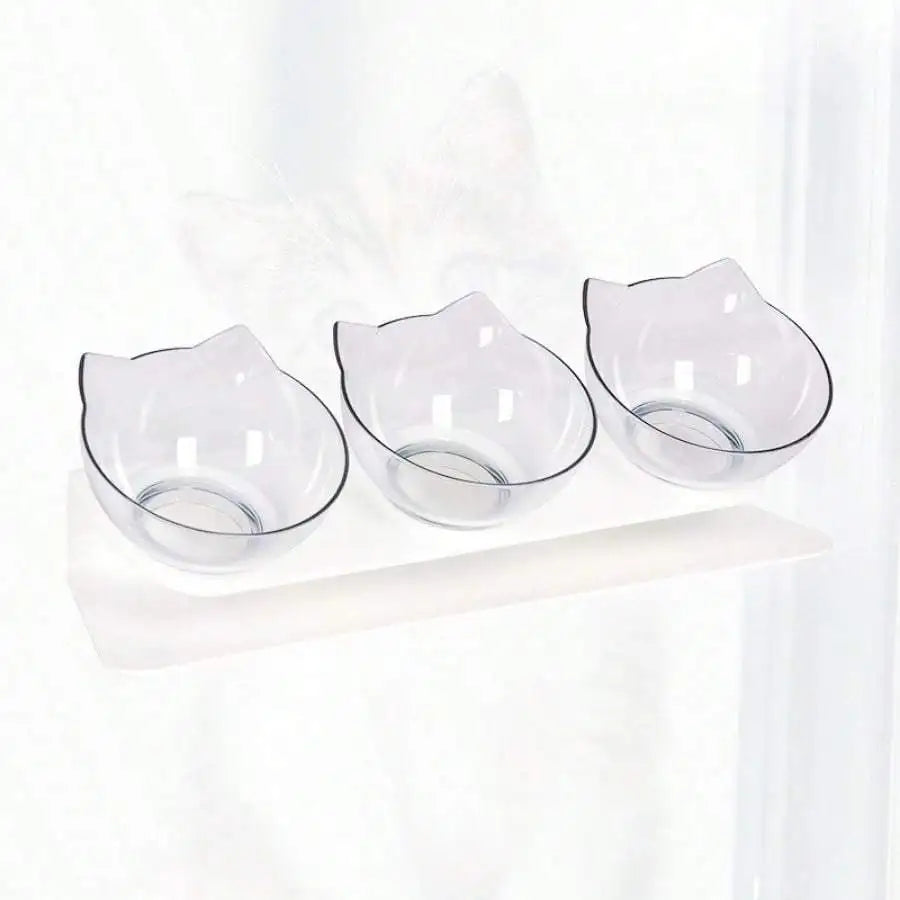 Station de repas triple avec gamelle pour chat transparente en polycarbonate cristal. Le support blanc incliné à 15 degrés offre une position ergonomique qui protège les cervicales de l'animal. Cette gamelle chat triple au design d'oreilles de chat est facile à nettoyer et anti-vomi. Un ensemble gamelle chaton minimaliste et esthétique pour un intérieur moderne.