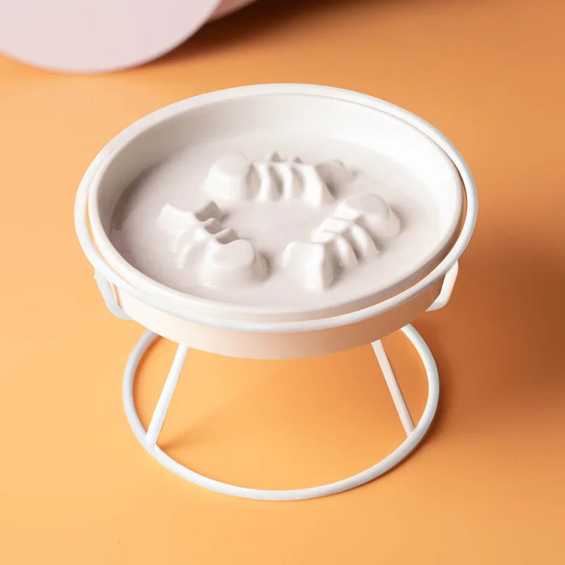 Accessoire indispensable à placer près de votre arbre pour chat : la gamelle anti-glouton surélevée en céramique blanche avec support en métal. Ce bol design présente des reliefs en forme d'arêtes de poisson pour ralentir le repas au pied de l'arbre chat. Idéale pour compléter l'espace de vie autour d'un arbre à chat multi-niveaux, cette gamelle ergonomique prévient les vomissements et assure une digestion saine après que votre félin ait grimpé sur son arbre pour chat préféré. Finition blanche minimaliste s