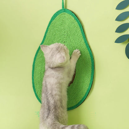 Chaton gris et blanc s'étirant sur un griffoir mural en sisal en forme d'avocat vert, installé sur un mur vert clair pour protéger les surfaces des griffades.