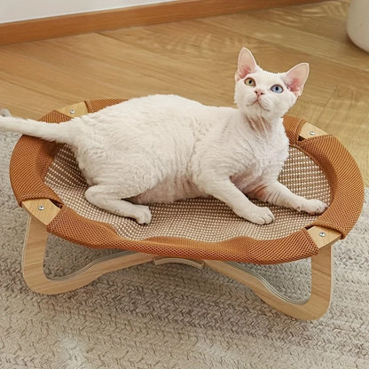 Hamac rafraichissant chat surélevé avec cadre en bois clair et surface de couchage en rotin respirant. L'image présente un chat blanc installé sur ce tapis rafraichissant chien et chat au design moderne. Alternative luxueuse au coussin rafraichissant pour chat, idéal pour une ventilation naturelle. Qualité prestige Les Trésors d'Owka.