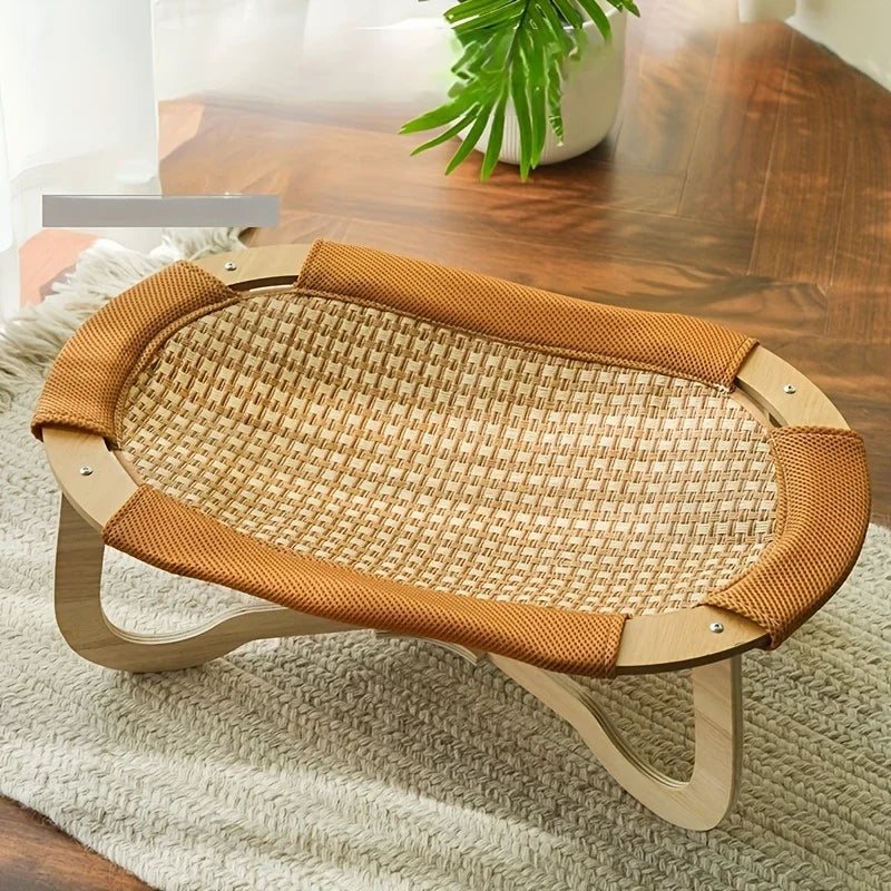 Lit hamac surélevé en bois clair avec surface en rotin respirante pour animaux. L'image présente ce tapis rafraichissant chien et chat au design minimaliste posé sur un tapis. Alternative élégante au coussin rafraichissant pour chat, idéal pour une ventilation naturelle. Qualité premium Les Trésors d'Owka.