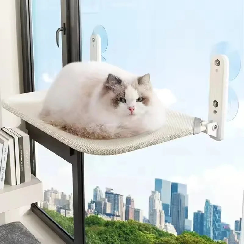 Hamac pour chat de fenêtre pliable sans câbles de suspension, modèle beige en tissu mesh respirant. L'image présente un chat blanc paisible sur un hamac chaton fixé par ventouses haute performance sur une baie vitrée. Lit de fenêtre gain de place et robuste pour hamac a chat de luxe. Qualité Les Trésors d'Owka.
