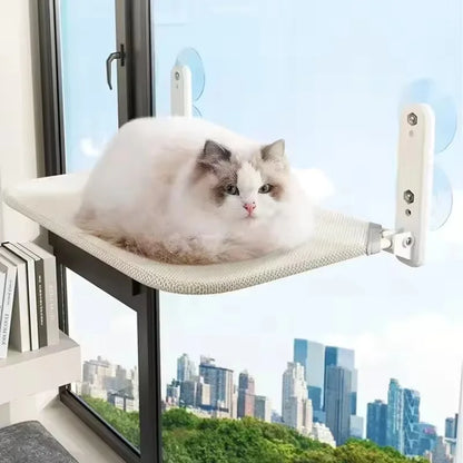 Hamac pour chat de fenêtre pliable sans câbles de suspension, modèle beige en tissu mesh respirant. L'image présente un chat blanc paisible sur un hamac chaton fixé par ventouses haute performance sur une baie vitrée. Lit de fenêtre gain de place et robuste pour hamac a chat de luxe. Qualité Les Trésors d'Owka.