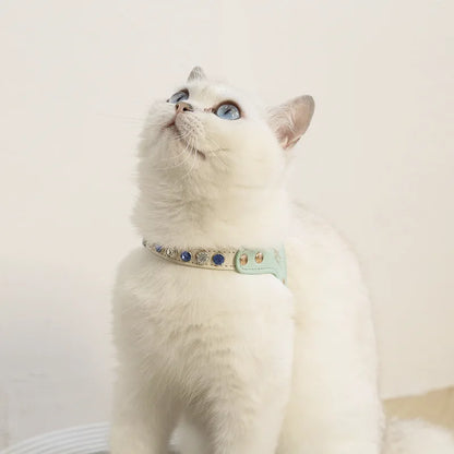 Mise en situation d'un harnais pour chat de luxe vert menthe serti de cristaux porté par un chat blanc aux yeux bleus. Ce harnais chat élégant de la gamme Maychan Fashion allie confort ergonomique et design haut de gamme. Un harnais de créateur parfait pour sublimer l'élégance naturelle de votre animal lors des sorties.