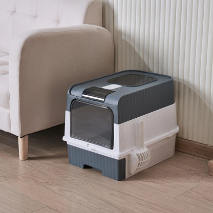 image de la litière cube grise posé dans un salon à coté d'un canapé