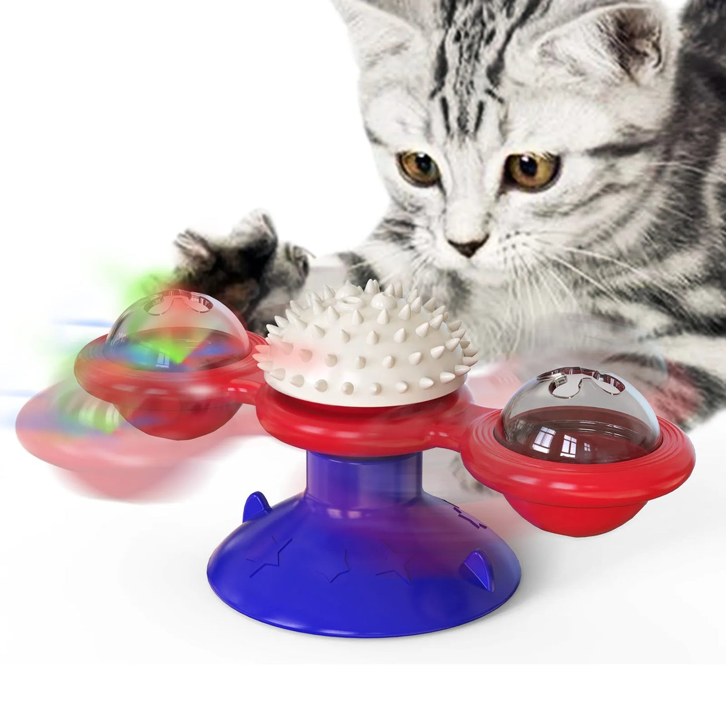 Jouet interactif tricolore (rouge, bleu et blanc) pour chat en forme de moulin à vent avec ventouse, doté d'une boule de massage centrale et de deux globes rotatifs contenant des billes lumineuses, présenté avec un chaton gris.