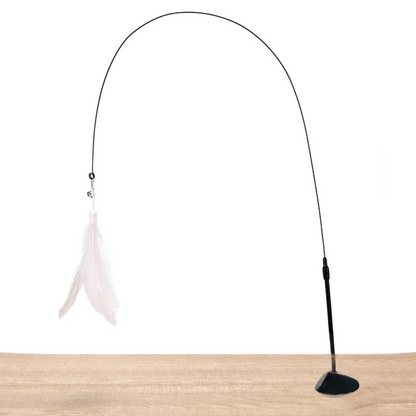 Jouet interactif pour chat composé d'une ventouse de fixation noire posée sur une surface en bois, d'une tige flexible noire formant une grande arche et d'un plumeau blanc suspendu avec une petite clochette.