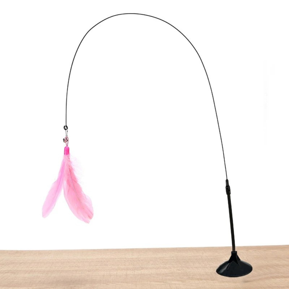 Jouet interactif pour chat avec ventouse de fixation noire posée sur un support bois, doté d'une tige flexible noire formant une grande arche et d'un plumeau rose suspendu avec grelot.