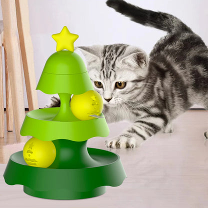 Jouet distributeur et gamelle anti glouton chat en forme de sapin vert avec balles rotatives jaunes. Ce circuit interactif stimule l'instinct de chasse tout en régulant la prise alimentaire. Cette gamelle glouton ludique prévient l'ennui et favorise une digestion saine pour votre félin, disponible chez Les Trésors d'Owka.