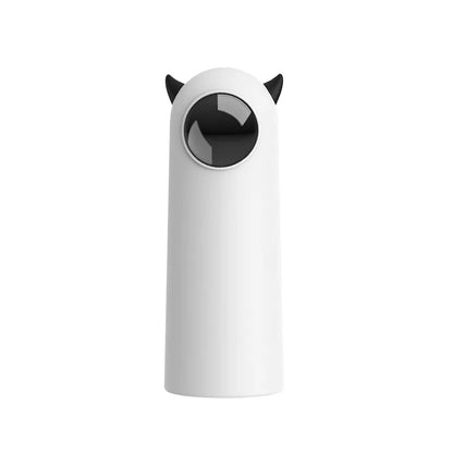 Jouet laser automatique pour chat blanc au design minimaliste avec petites cornes noires, doté d'une lentille circulaire de projection frontale pour un jeu interactif et autonome.
