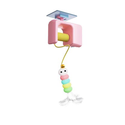 Jouet pour chat automatique de type ascenseur électrique avec boîtier rose et enrouleur. Ce jouet chat interactif suspend une chenille multicolore en pompons munie d'un grelot et de plumes blanches. Un accessoire technologique unique parmi les jouet animaux pour stimuler l'instinct de chasse en toute autonomie grâce à son système de fixation universel.