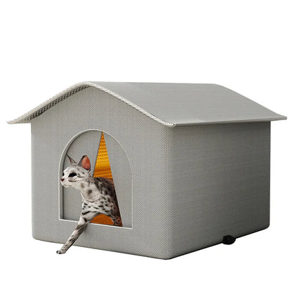 Maison a chat en forme de niche grise avec intérieur ocre matelassé, montrant un chat sortant de l'abri. Ce modèle d'abris chat élégant est détouré sur fond blanc. Maison chat exterieur et intérieur pliable et isolée, idéale pour un repos sécurisé. Qualité premium Les Trésors d'Owka.