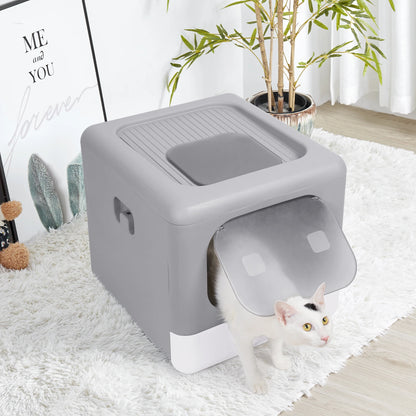 Chat blanc sortant par la porte frontale transparente d'un bac à litière chat fermé gris et blanc au design cubique. Installé sur un tapis blanc dans un salon moderne, ce bac a litiere est une solution propre et esthétique, idéale comme bac à litière pour chaton.