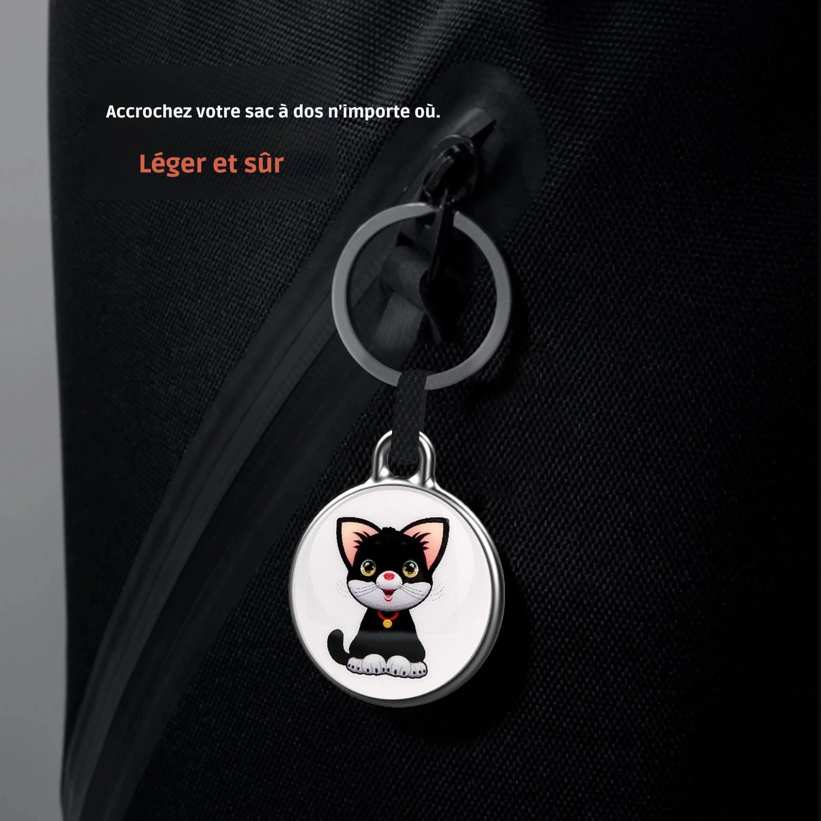 Médaillon de collier gps chat illustré d'un chaton noir, utilisé ici comme porte-clé sécurisé sur la fermeture éclair d'un sac à dos noir. Le visuel inclut les mentions « Léger et sûr » et « Accrochez votre sac à dos n'importe où ». Un dispositif de suivi ultra-compact, idéal pour être intégré à un collier gps pour chaton ou pour protéger vos effets personnels grâce à ce collier gps polyvalent.