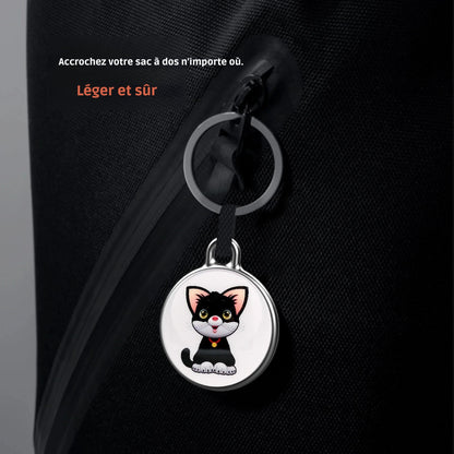 Médaillon de collier gps chat illustré d'un chaton noir, utilisé ici comme porte-clé sécurisé sur la fermeture éclair d'un sac à dos noir. Le visuel inclut les mentions « Léger et sûr » et « Accrochez votre sac à dos n'importe où ». Un dispositif de suivi ultra-compact, idéal pour être intégré à un collier gps pour chaton ou pour protéger vos effets personnels grâce à ce collier gps polyvalent.