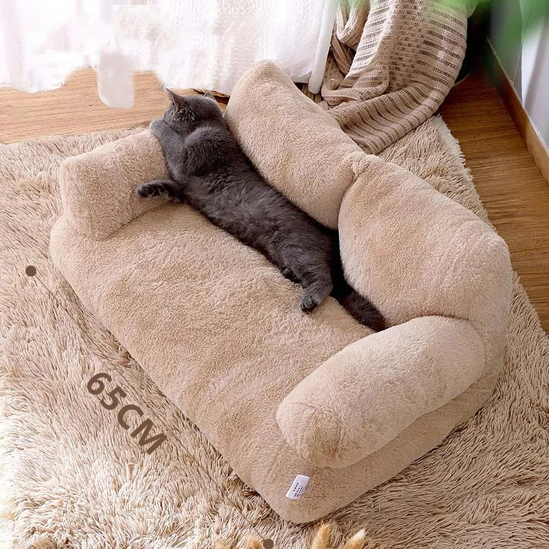 Panier chat type canapé beige de 65cm avec dossier rembourré et accoudoirs. L'image montre un chaton étiré sur ce coussin pour chat grand format en peluche douce. Lit sofa spacieux, chaud et design pour un confort type coussin a chat haut de gamme. Qualité Les Trésors d'Owka.