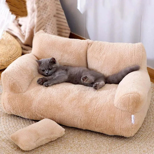 Panier chat en forme de canapé sofa beige avec dossier et accoudoirs moelleux. L'image présente un chaton étendu sur ce coussin pour chat en peluche Sherpa avec un petit oreiller assorti. Lit sofa luxueux, chaud et design pour un confort type coussin a chat premium. Qualité Les Trésors d'Owka.