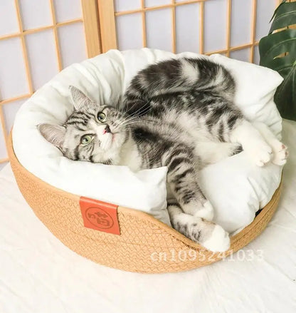 Chat tigré étiré confortablement dans un panier rond en corde tressée beige, montrant le grand coussin blanc moelleux et le rebord abaissé pour un accès facile.