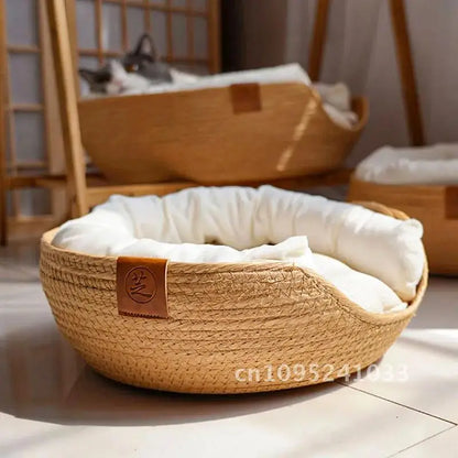 Panier pour chat au design moderne en corde tressée beige avec rebord incurvé, écusson décoratif en cuir et coussin blanc moelleux de haute qualité.