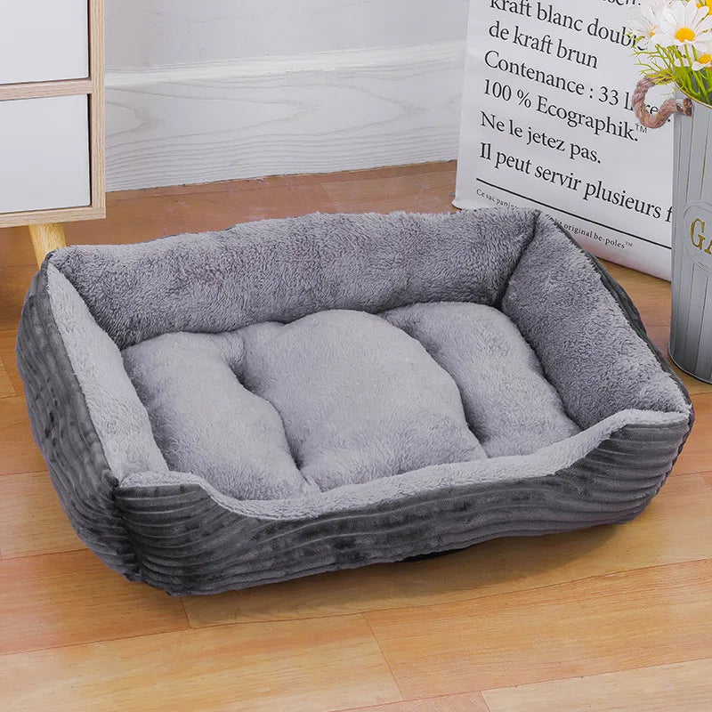 Panier chat rectangulaire gris avec extérieur en velours côtelé résistant et intérieur en peluche grise douce. L'image montre ce coussin pour chat capitonné au design sobre et élégant. Lit douillet, chaud et profond pour un confort de type coussin a chat haut de gamme. Qualité premium Les Trésors d'Owka.