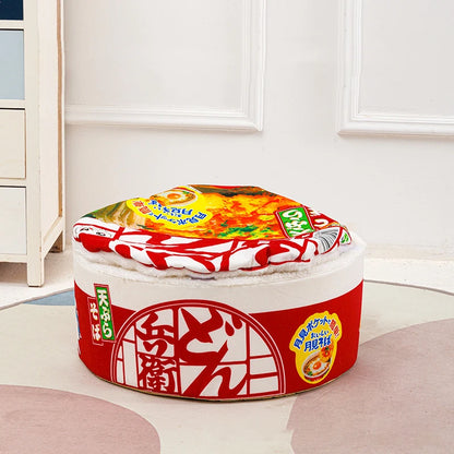 Panier chat original en forme de pot de nouilles japonaises fermé avec couvercle moelleux. L'image présente un coussin pour chat insolite au design ramen rouge et blanc, idéal pour une cachette sécurisée. Lit douillet et rigolo pour un confort type coussin a chat. Qualité premium Les Trésors d'Owka.