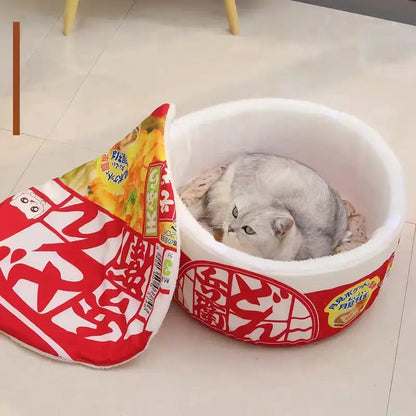 Panier chat original en forme de cup noodles japonais ouvert. L'image montre un chat blanc endormi sur un coussin pour chat ultra-moelleux imitant des nouilles. Lit pour chat insolite, rond et profond pour un confort type coussin a chat. Qualité premium Les Trésors d'Owka.