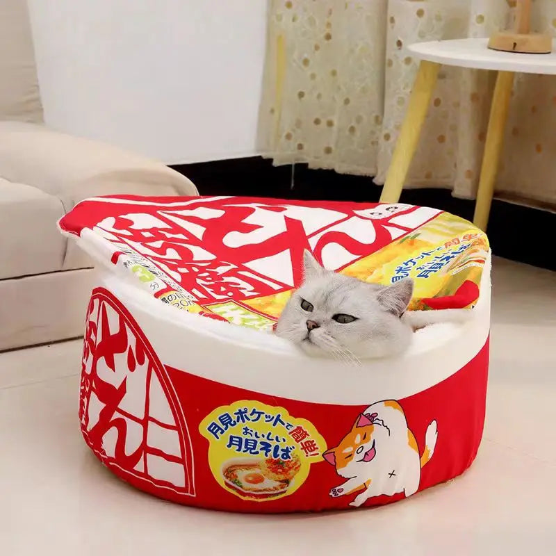Panier chat original en forme de bol de nouilles instantanées japonaises (Ramen) rouge et blanc. L'image montre un chat blanc à l'intérieur de ce coussin pour chat insolite avec couvercle. Lit douillet, rigolo et ultra-confortable pour coussin a chat. Qualité premium Les Trésors d'Owka.