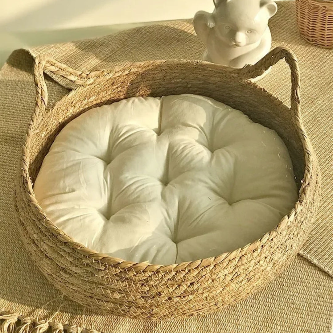 Panier rond pour chat en osier tressé naturel avec oreilles décoratives, équipé d'un grand coussin blanc capitonné ultra-moelleux pour un confort maximal.