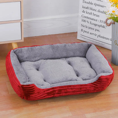 Panier chat rectangulaire bicolore rouge et gris avec extérieur en velours côtelé premium. L'image présente ce coussin pour chat capitonné et ultra-moelleux dans un décor de maison moderne. Lit douillet, chaud et profond pour un confort de type coussin a chat haut de gamme. Qualité Les Trésors d'Owka.