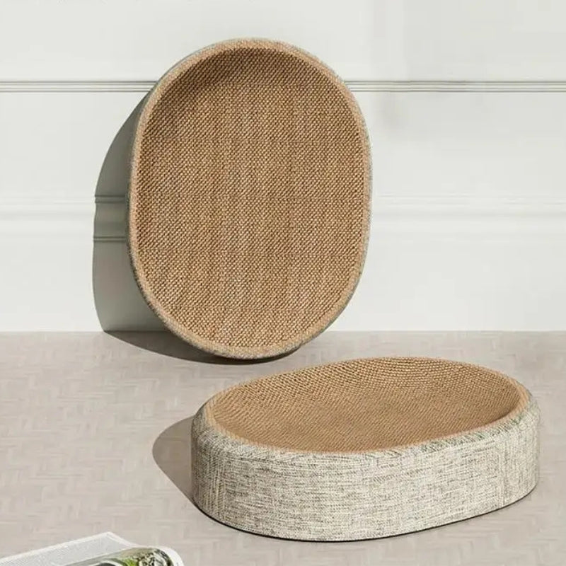 Panier griffoir pour chat de forme ovale avec surface de griffage en carton ondulé haute densité et contour en tissu beige chiné, présenté sous deux angles différents sur un sol clair.