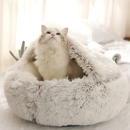 Chat blanc à poils longs installé dans un panier grotte apaisant beige crème en peluche shaggy ultra-moelleuse, offrant un refuge sécurisant et un confort thermique optimal.