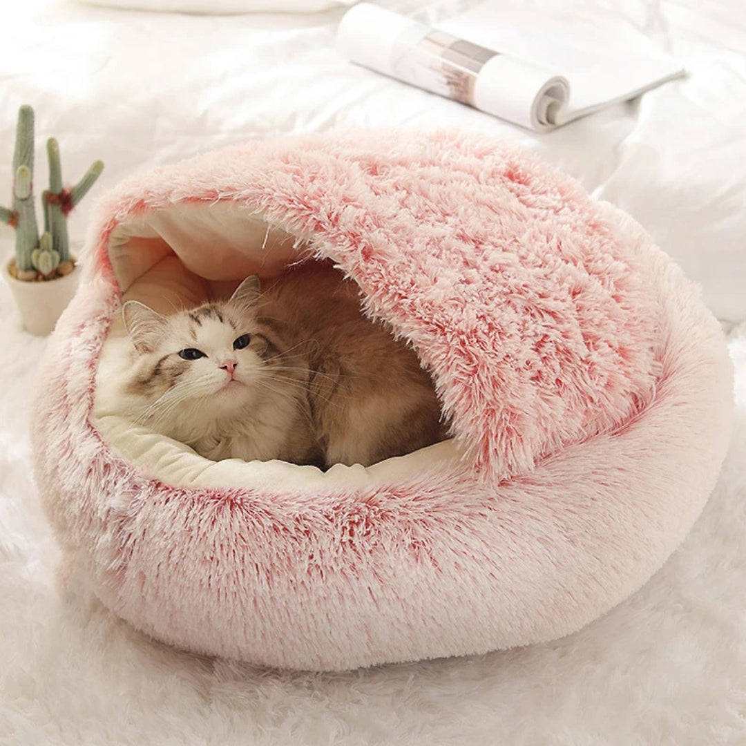 Chat installé confortablement dans un panier grotte apaisant rose en peluche shaggy ultra-douce, avec toit protecteur souple créant un refuge sécurisant et chaud.
