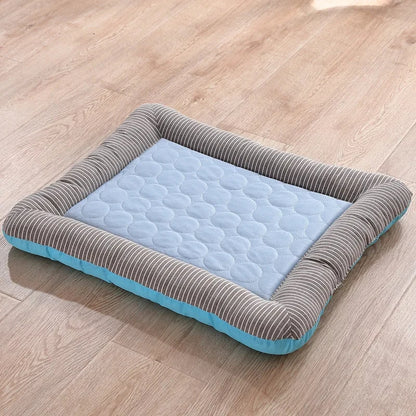 Tapis rafraichissant chien et chat avec bords rembourrés rayés gris et blanc sur un parquet. L'image montre le lit et coussin rafraichissant pour chat bleu matelassé avec une technologie textile soie glacée. Panier d'été auto-rafraîchissant, respirant et confortable. Qualité premium Les Trésors d'Owka.