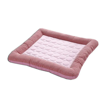 Tapis rafraichissant chien et chat avec bords rembourrés rayés roses et rouges sur fond blanc. L'image présente ce coussin rafraichissant pour chat rose matelassé en soie glacée. Panier d'été auto-rafraichissant, respirant et moelleux, idéal comme tapis rafraichissant chat de qualité supérieure Les Trésors d'Owka.