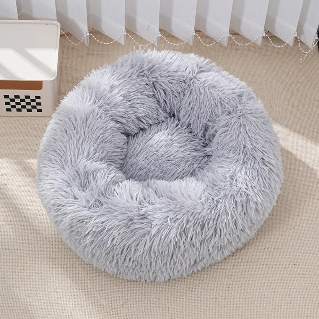 Panier rond apaisant pour chat et petit chien en fausse fourrure grise ultra-moelleuse, avec bords surélevés rembourrés pour un effet nid protecteur et anti-stress.