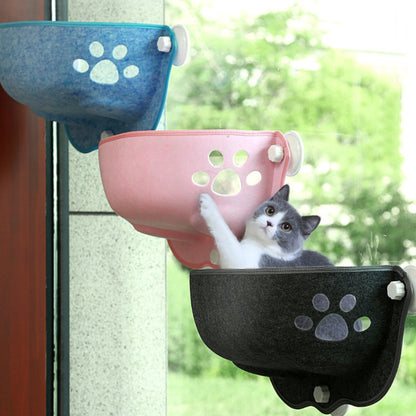 Trois modèles de hamacs de fenêtre pour chat en feutre de couleurs bleu, rose et gris anthracite, fixés en escalier sur une baie vitrée grâce à des ventouses à vis sécurisées.