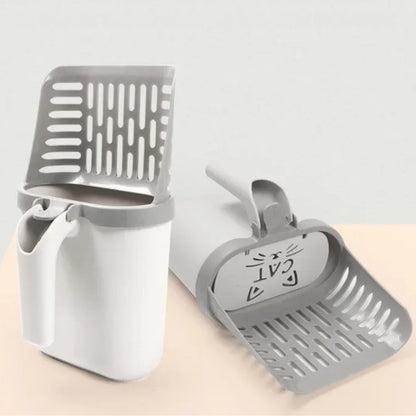 Pelle à litière pour chat grise et blanche avec réservoir hermétique et trappe décorée d'une tête de chat, montrant le système de tamisage et le bac de stockage pour un nettoyage sans odeurs.