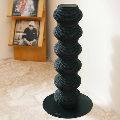 Haut poteau à griffer sculptural pour chat en forme de colonne ondulée noire, fabriqué en corde tressée haute densité sur une base circulaire stable.