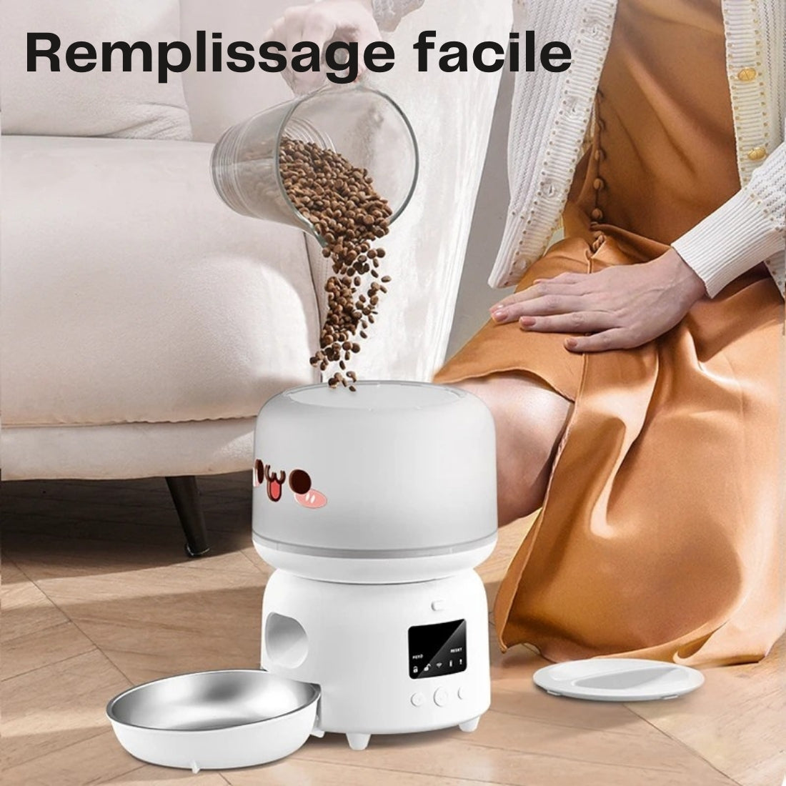 Femme versant des croquettes dans le réservoir supérieur d'un distributeur automatique blanc au design mignon, illustrant la facilité de remplissage par le haut et le bol en acier inoxydable.