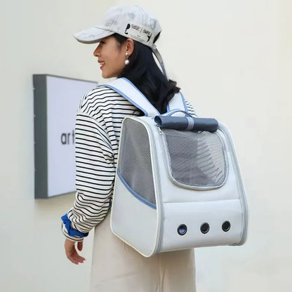 Femme portant un sac à dos de transport pour chat blanc avec finitions bleu turquoise, montrant un chat blanc regardant à travers une large fenêtre en filet panoramique avec trois œillets d'aération métalliques.